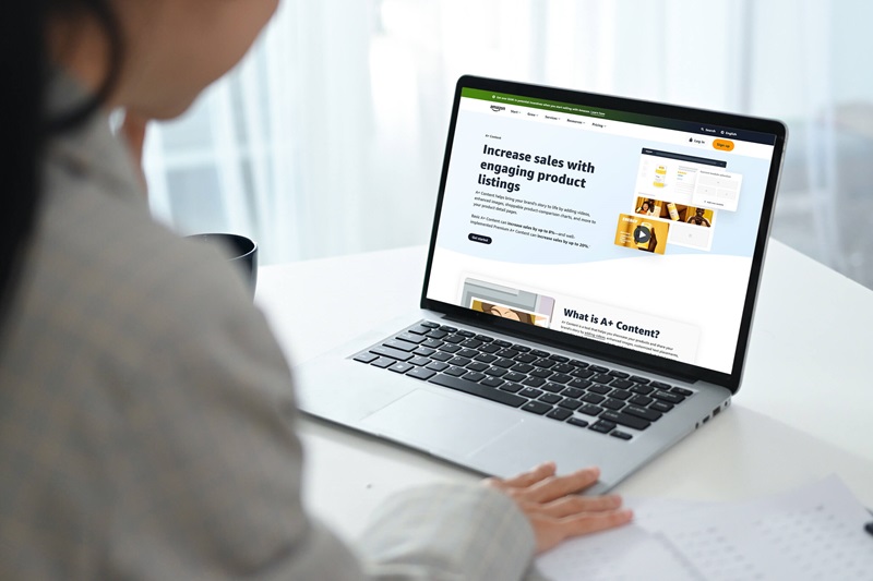 Over-the-shoulder view of a person browsing the Amazon A+ Content Services (FAQs) by Brandock, showing a screen with Increase sales with engaging product listings.