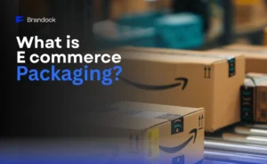 An informative e-commerce guide banner by Brandock featuring the headline "What Is eCommerce Packaging?", with a dark blue text overlay on the left next to a visual background showing Amazon cardboard shipping boxes moving down a warehouse conveyor belt.